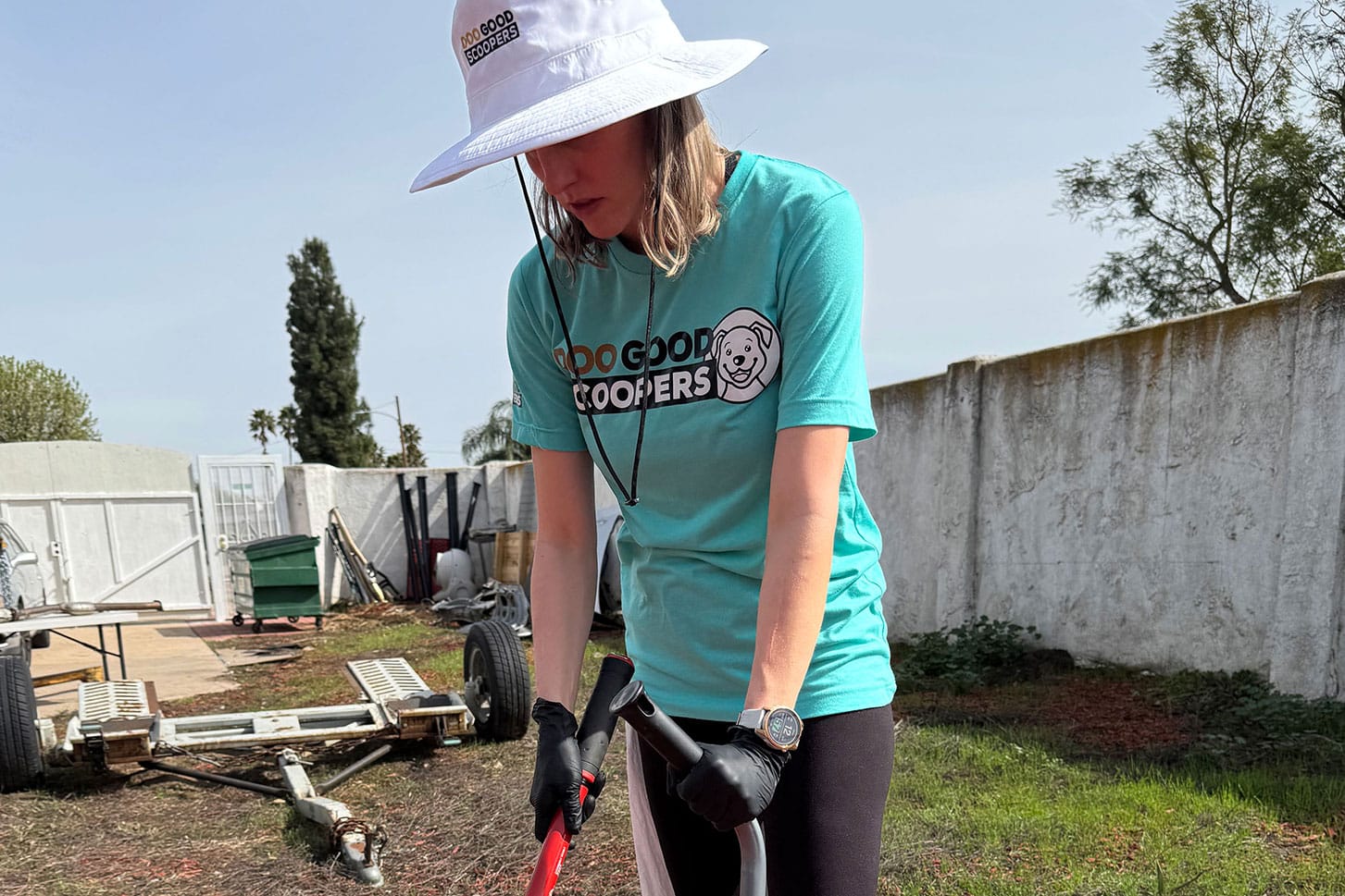 DooGoodScoopers technician scooping dog waste in a Fontana backyard